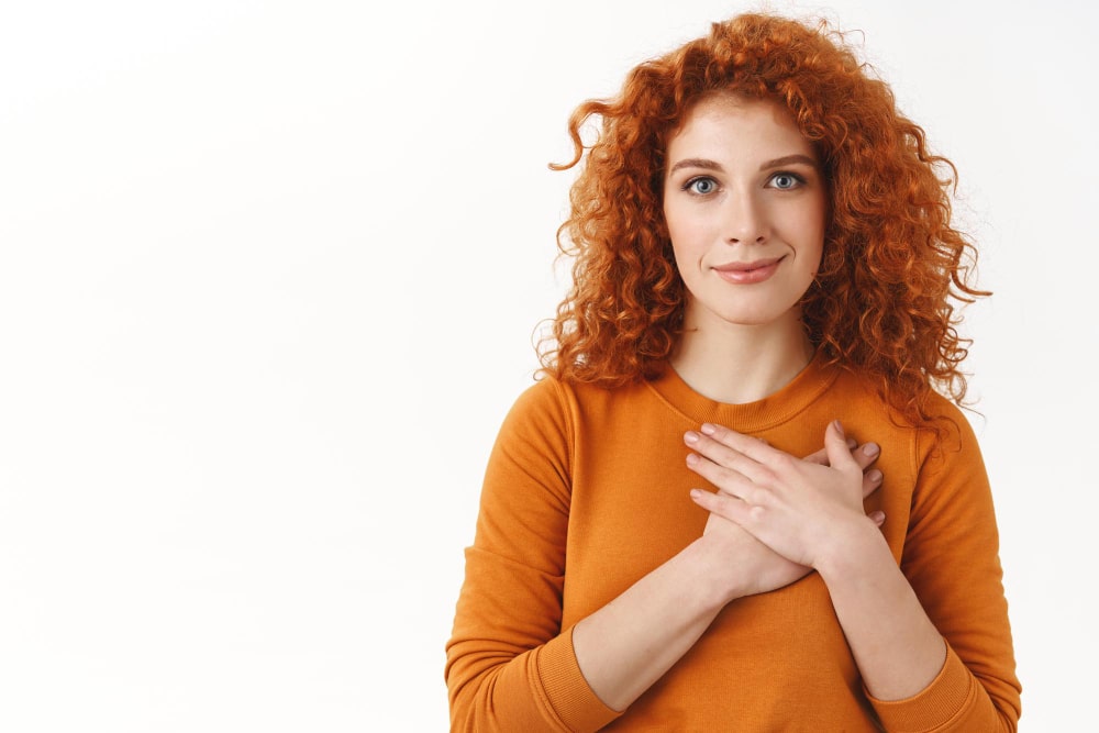 your-support-mean-lot-touched-tender-gorgeous-redhead-woman-with-blue-eyes-curly-haircut-press-hands-to-heart-grateful-smiling-pleased-thankful-for-nice-gift-appreciate-help-white-background-min
